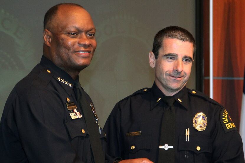 Dallas police Chief David O. Brown, left, hands Deputy Chief David Pughes his new badge at a...