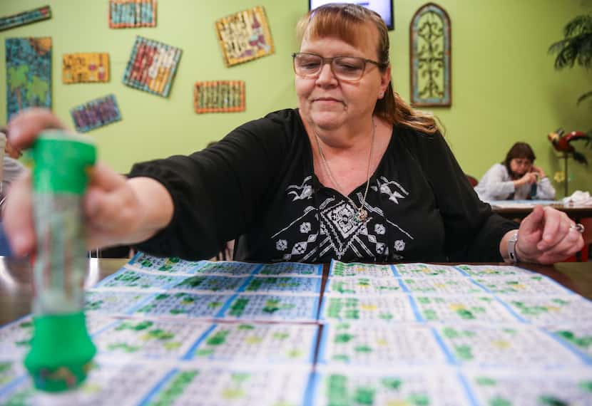 Jeannie Masconi, of Duncanville, Texas, marks her cards during a round of bingo at Jackpot...