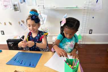 Two girls draw during an activity at Early Partners, a child care center in New Orleans....