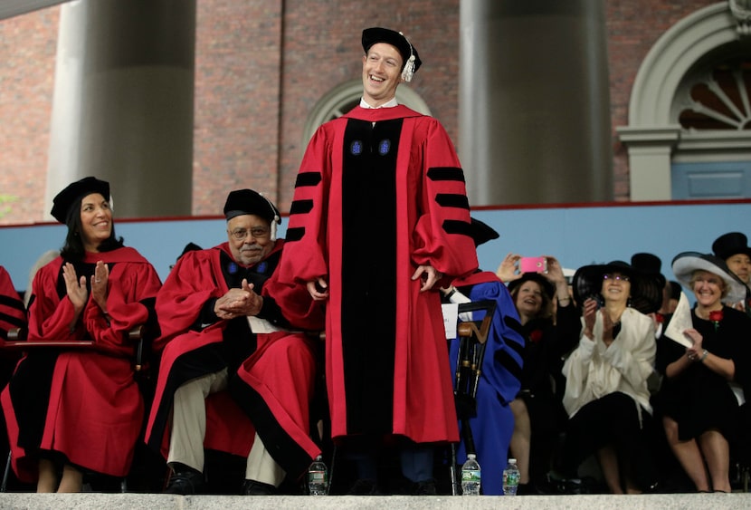 Facebook CEO and Harvard dropout Mark Zuckerberg, center, smiles as he is introduced before...