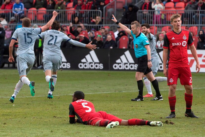 Toronto FC defender Ashtone Morgan, center, and Liam Fraser, right, react after Chicago...