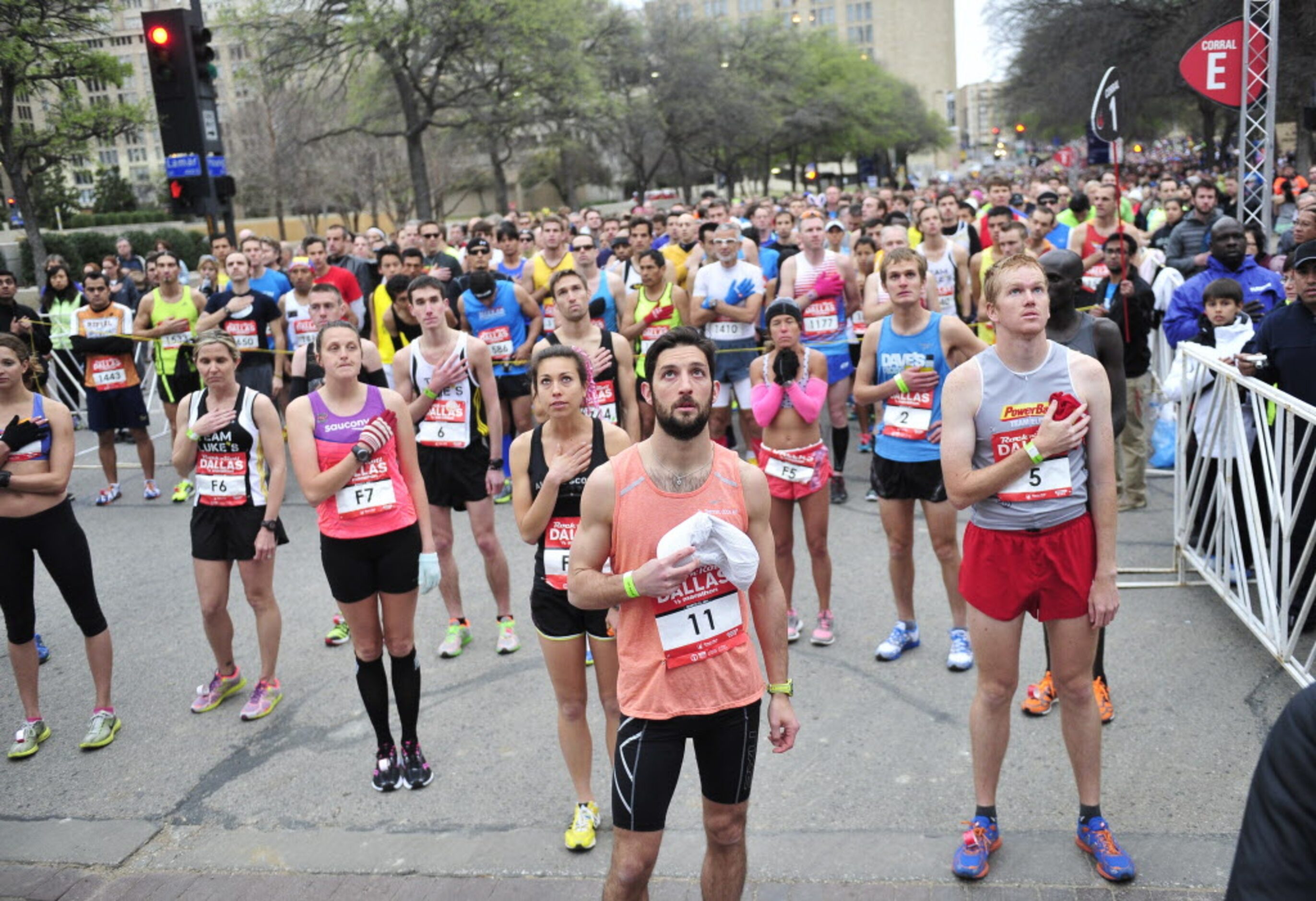 Runners listen as the national anthem is played before the start of the Dallas Rock N' Roll...