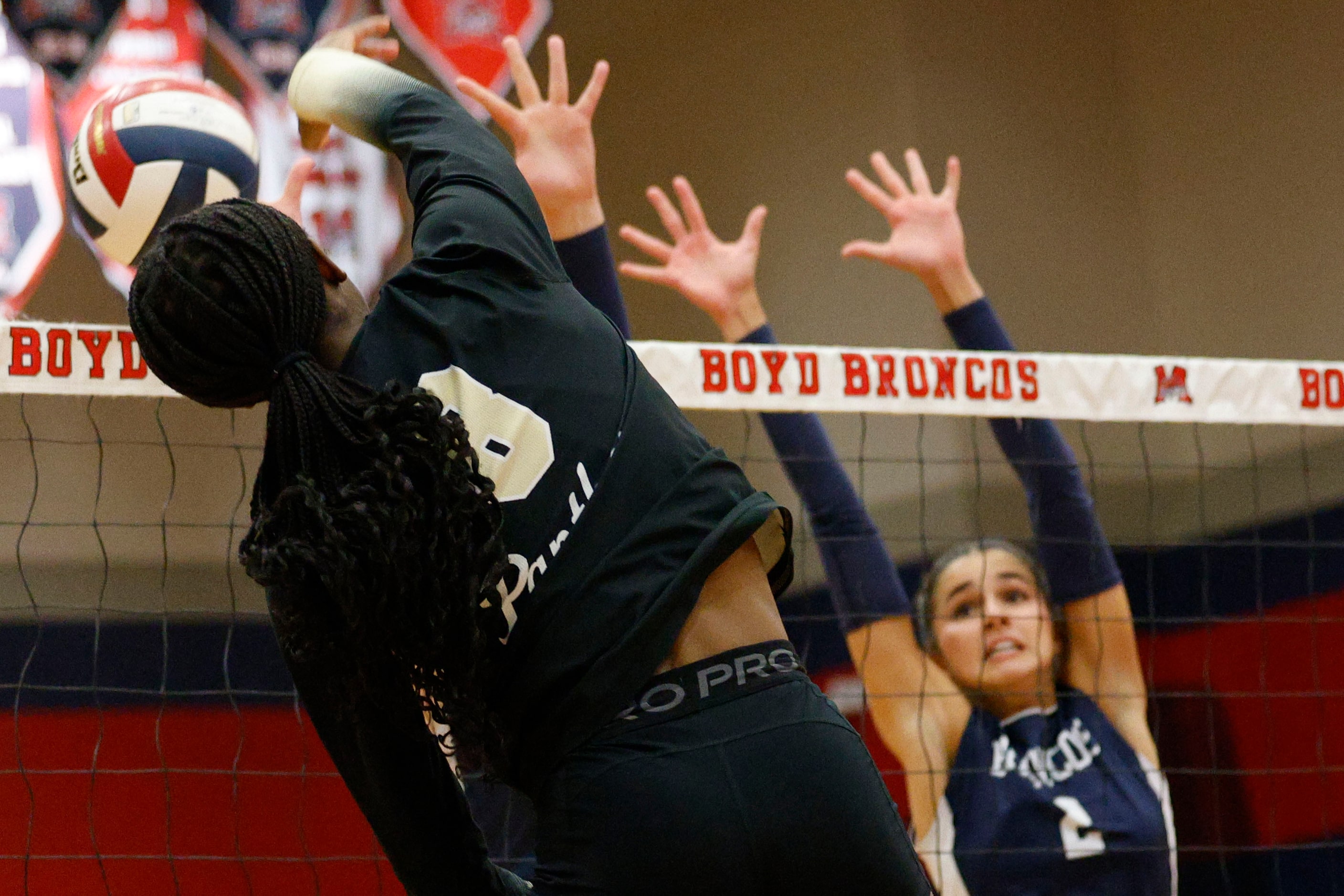 Plano East's Simone Heard (8) spikes the ball past McKinney Boyd's Keira Bose (2) in the...