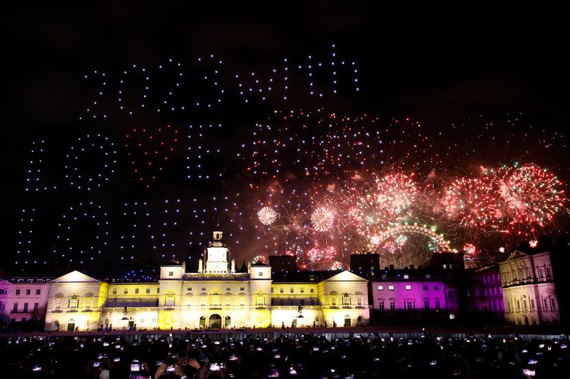 People watch a drone light display and the fireworks from Horse Guards Parade in central...