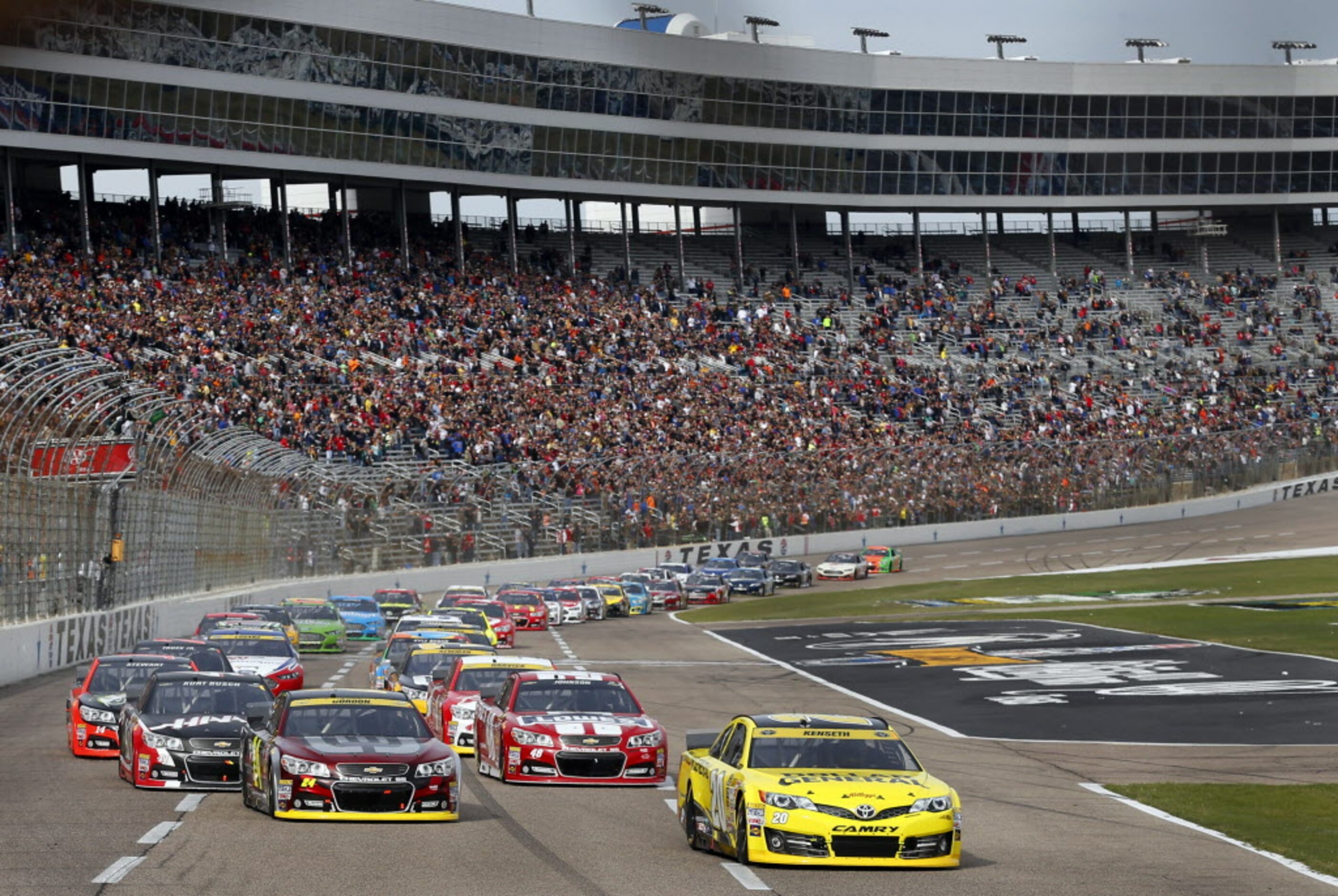 The green flag drops on the start of the AAA Texas 500 as the field of cars race down the...