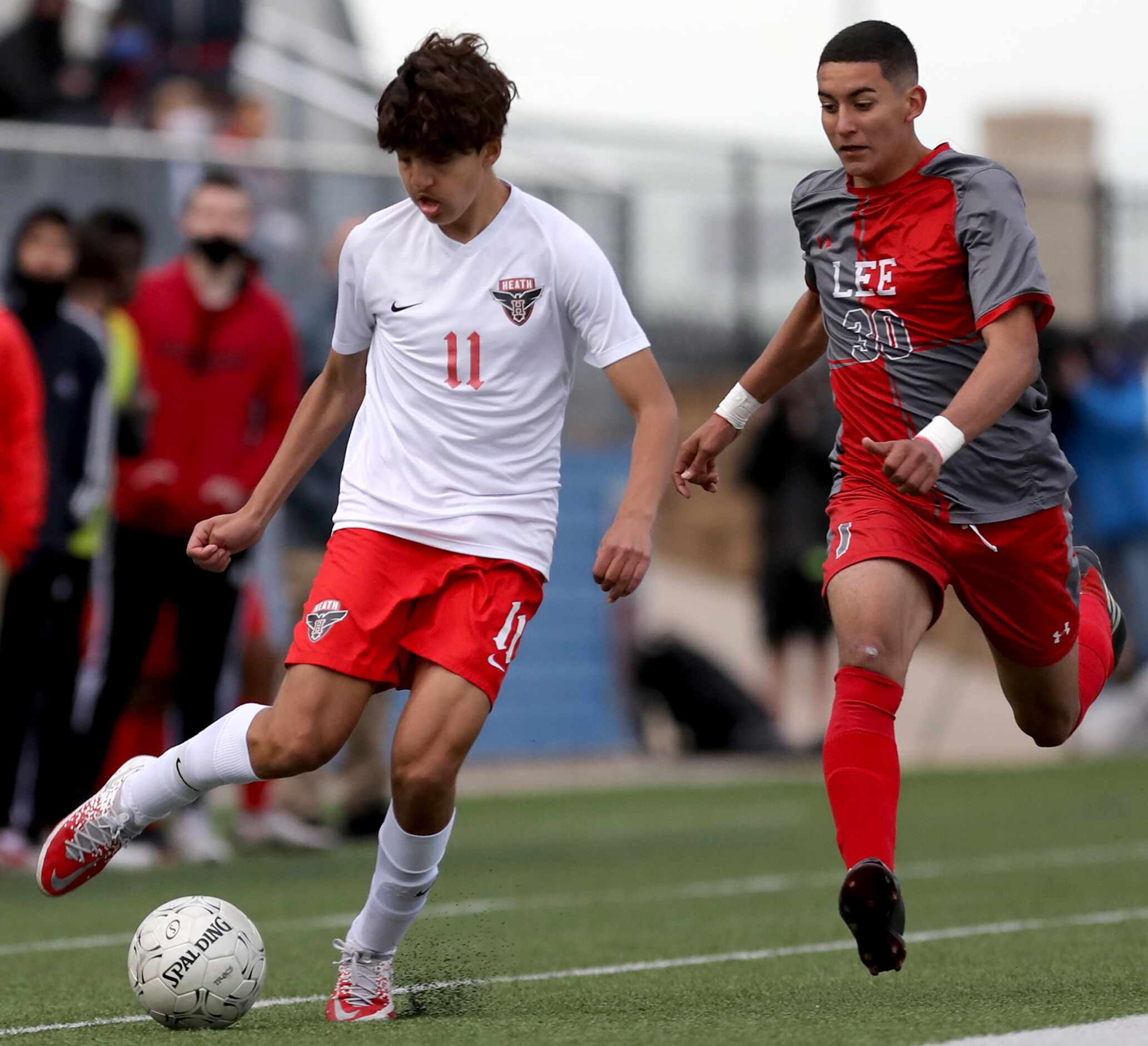 Rockwall-Heath's Donovan Faletto (11) and SA Lee's Jesus Blanco (30) chase after the ball...