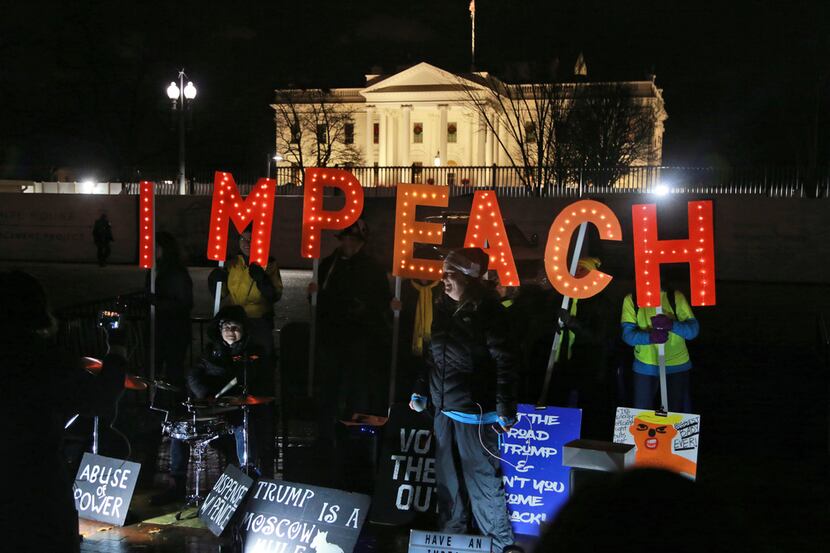 Protesters hold signs in front of the White House Tuesday, Dec. 17, 2019 in Washington. (AP...