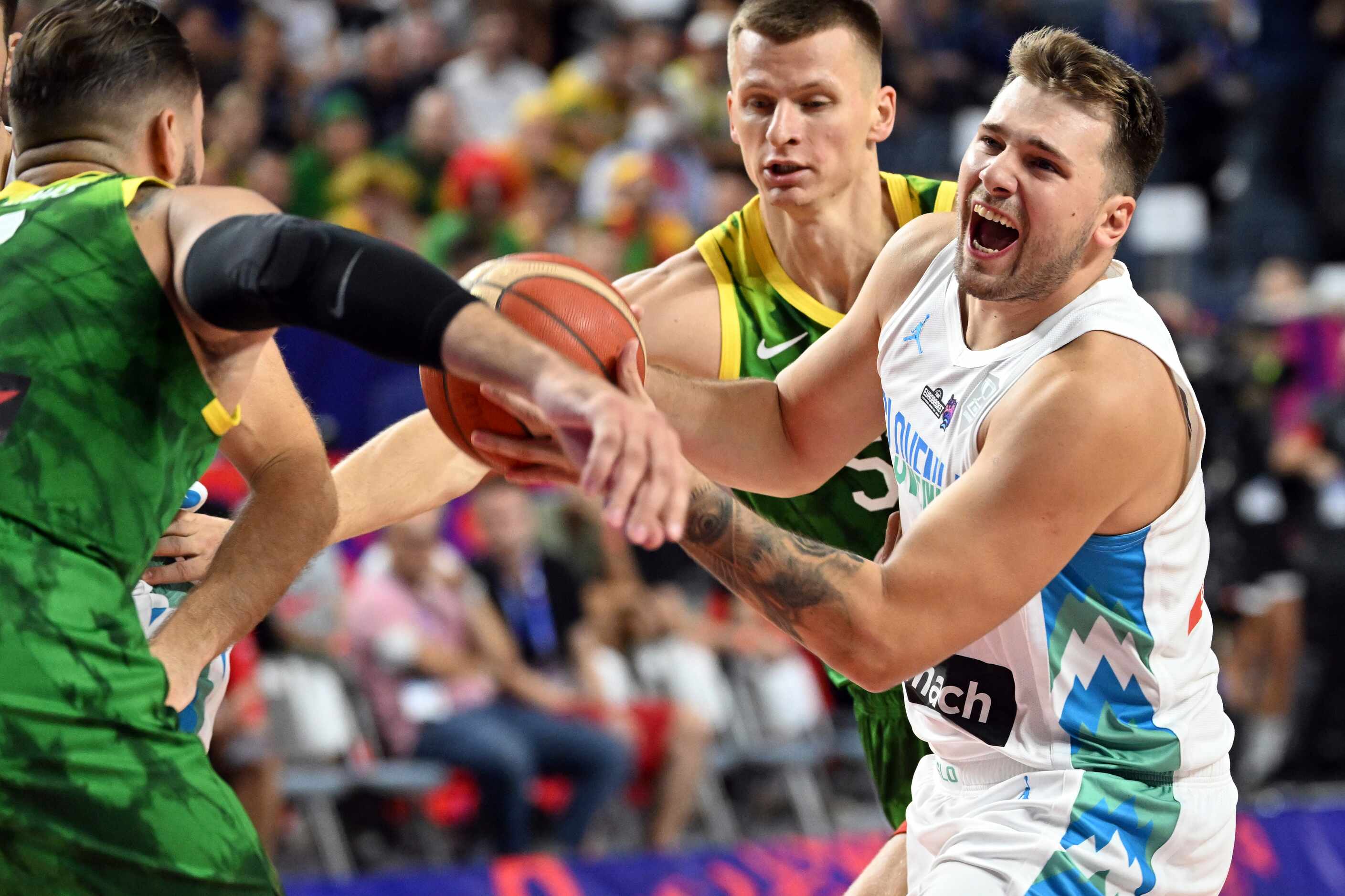 Slovenia's Luka Doncic, right, and Lithuania's Marius Grigonis, left, fight for the ball...