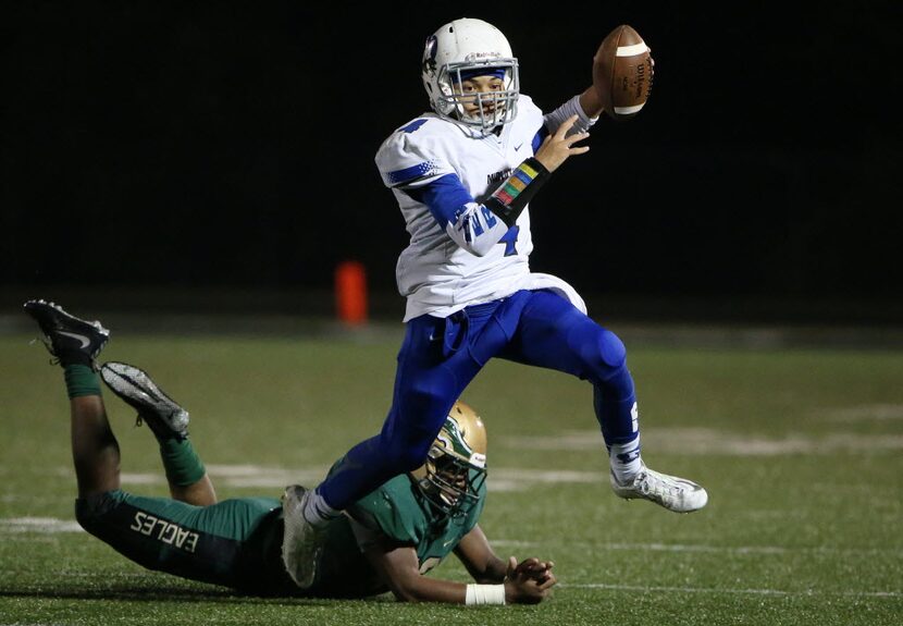 Midlothian quarterback Jerreth Sterns (4) avoids a tackle while carrying the ball in the...