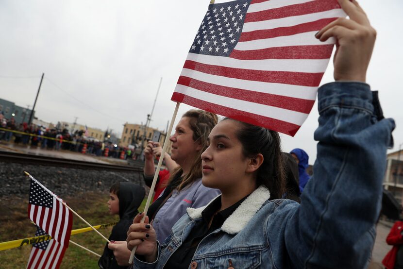 People look on as a train carrying the casket of former U.S. President George H.W. Bush to...