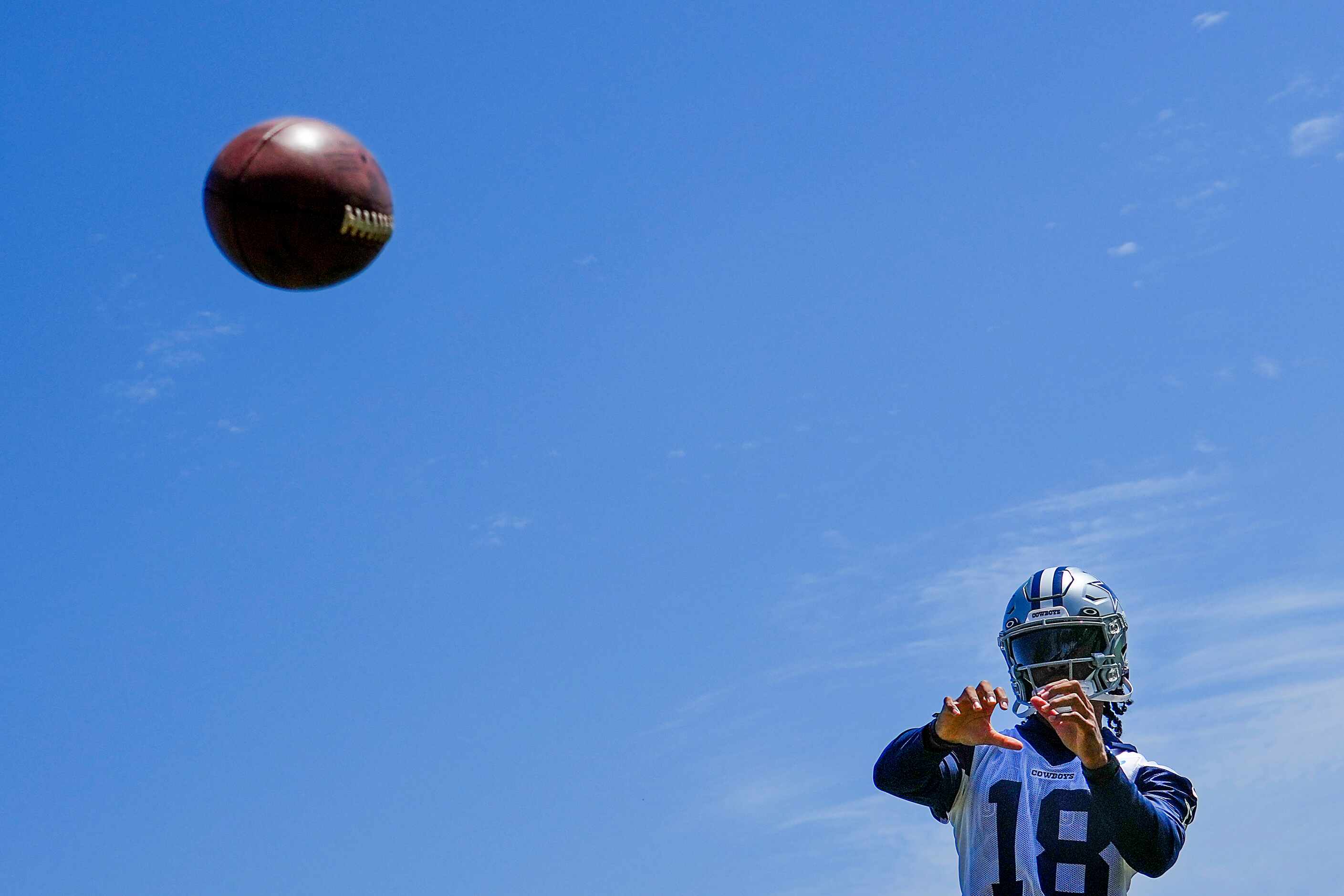 Dallas Cowboys wide receiver Jalen Tolbert catches a ball from a football throwing machine...