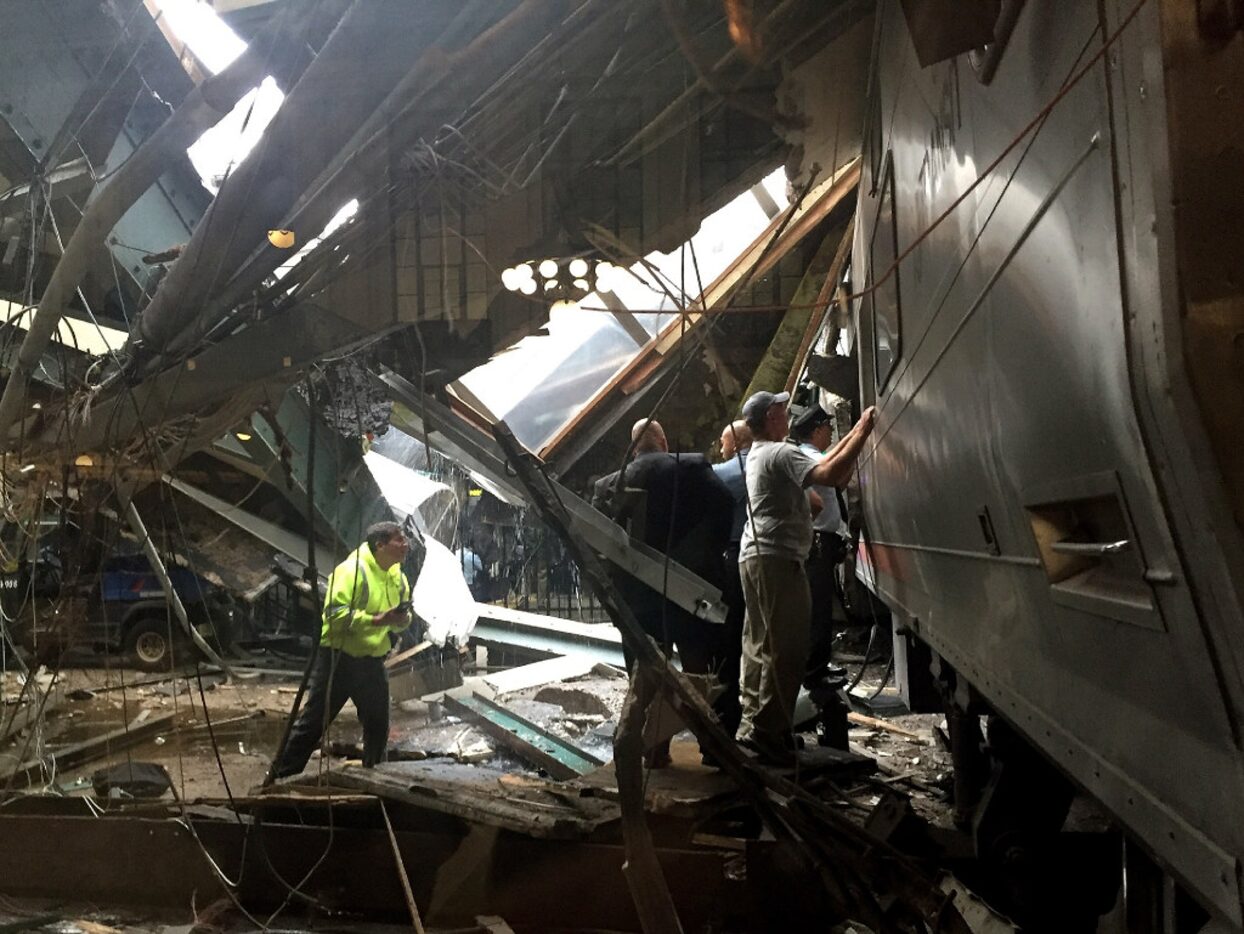 Train personnel survey the NJ Transit train that crashed in to the platform at the Hoboken...