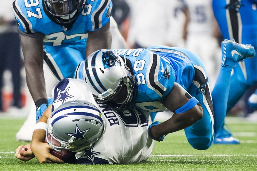 Dallas Cowboys quarterback Tony Romo (9) is sacked by Carolina Panthers outside linebacker...