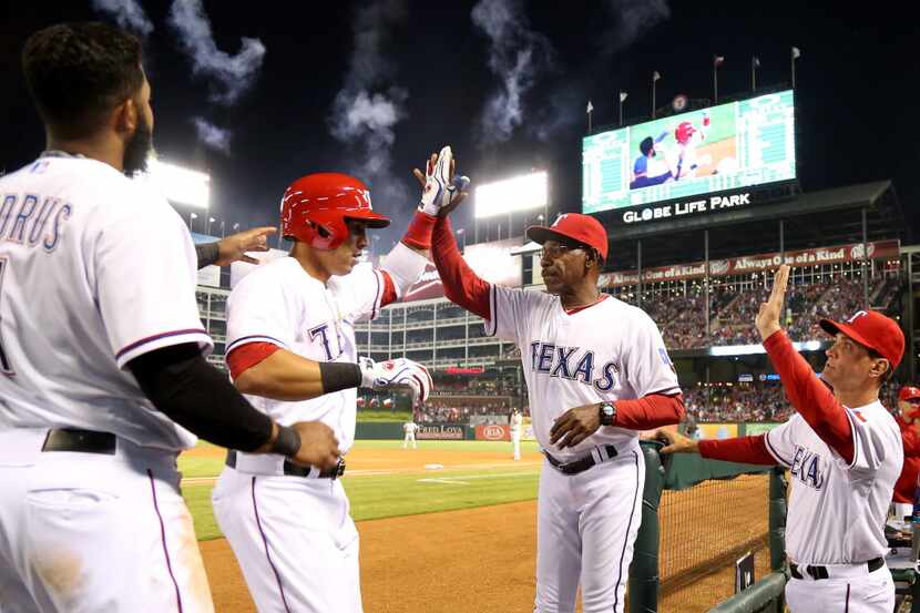 Texas Rangers center fielder Leonys Martin (2) is met by manager Ron Washington (38) after...