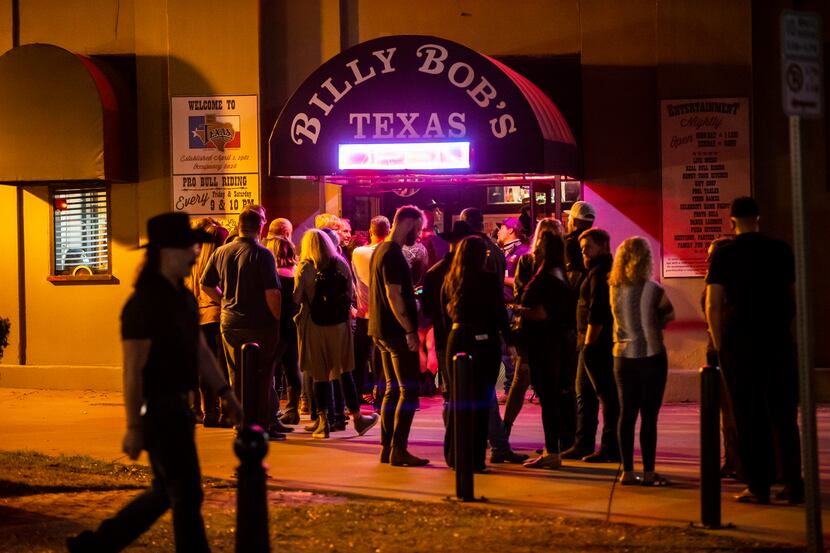 Patrons, largely without masks, line up to enter Billy Bob’s Texas in Fort Worth, Friday,...