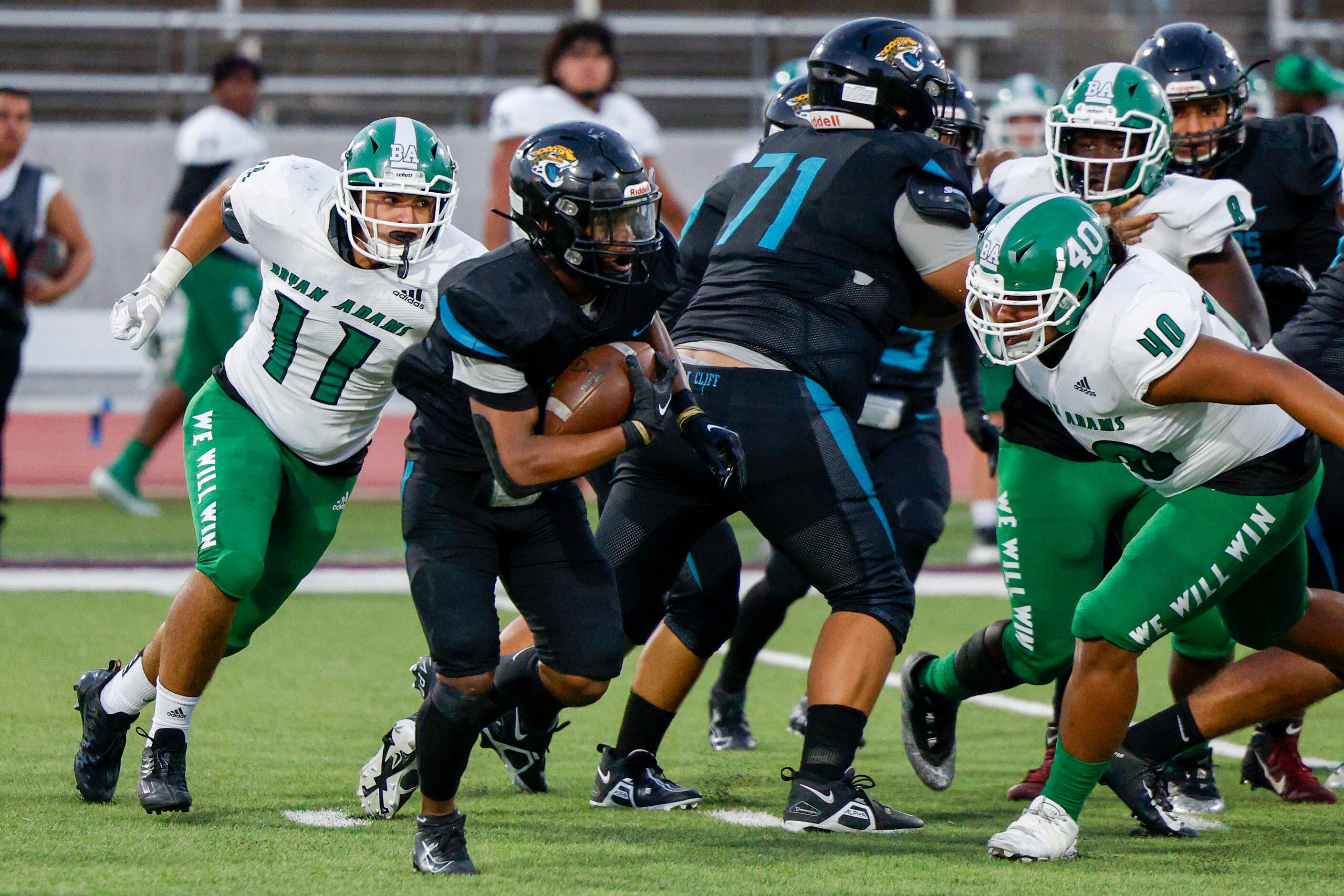 Bryan Adams linebacker Buster McCrary (11) and defensive end Andrew Castillo (40) pursue...