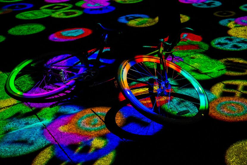 A bike rests while being lit up by Digital Icons by Miguel Chevalier during Aurora in Dallas...