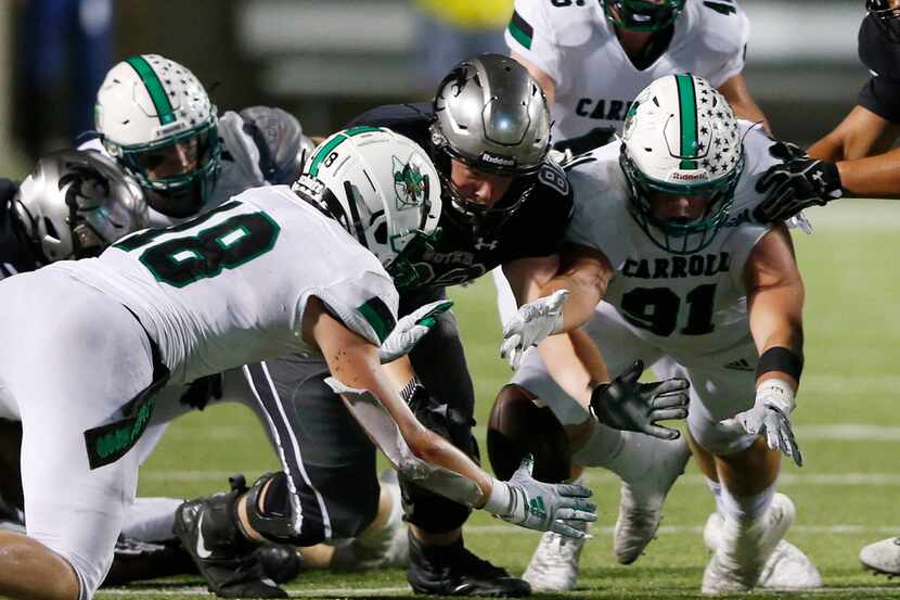 Southlake Carroll's Dillon Springer (91) dives for the fumbled ball and gains possession of...