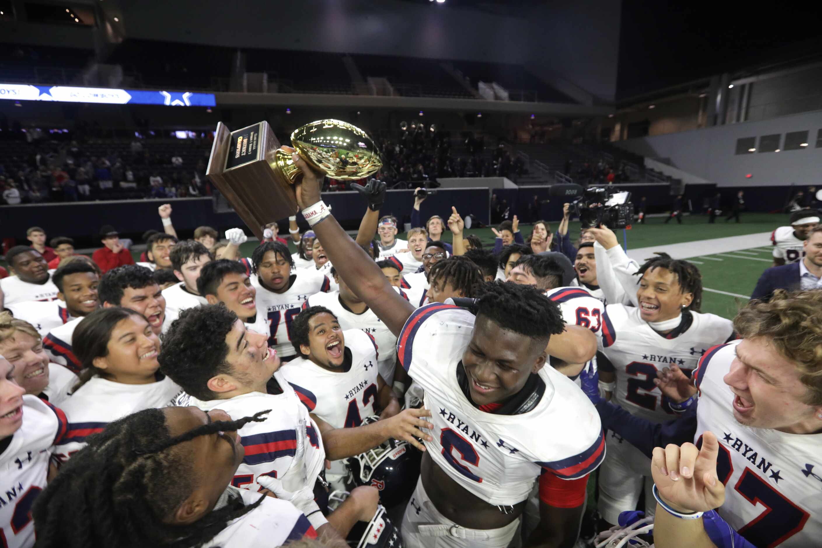 The Denton Ryan High School team celebrates after winning a football game against Frisco...