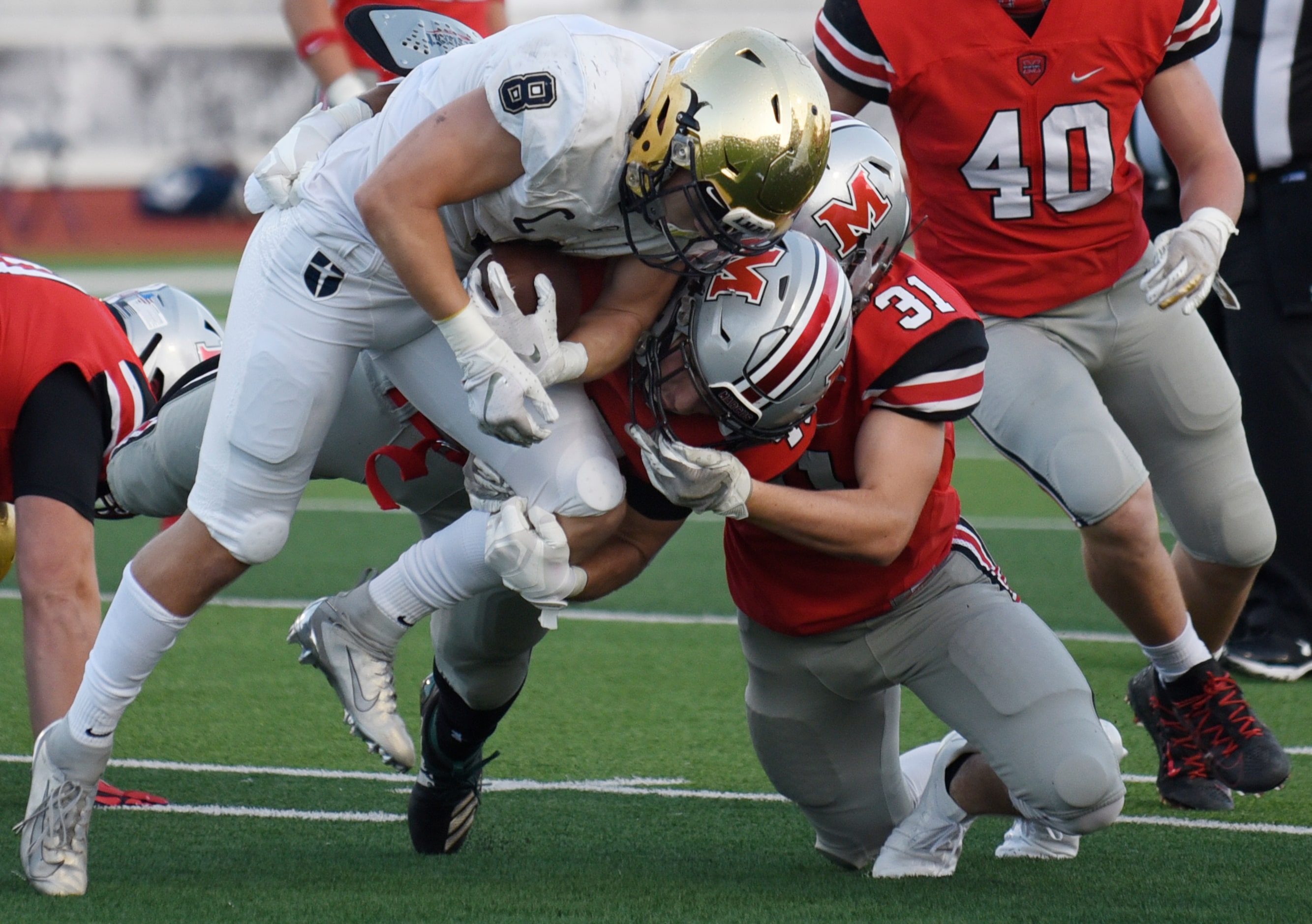 Jesuit senior running back Jake Taylor (8) tackled by Flower Mound Marcus defenders senior...