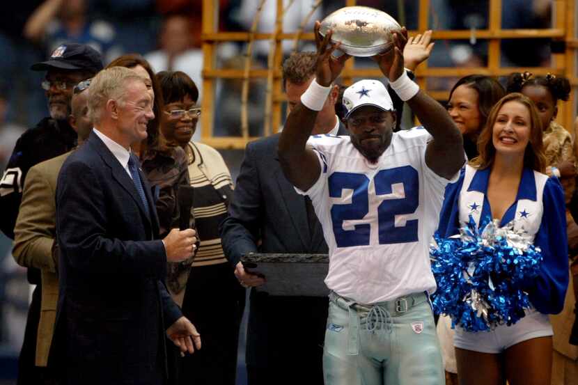 Dallas Cowboys running back Emmitt Smith (22) holds up the trophy he received from team...
