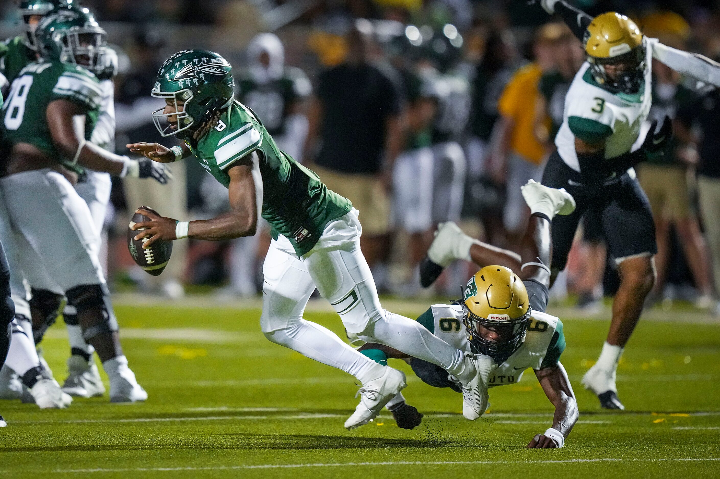 Waxahachie quarterback Ramon McKinney Jr. (8) is tripped up by DeSoto defensive back Aundre...