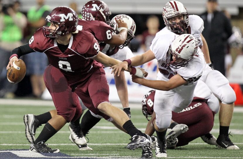 Mildred quarterback Nic Shimonek (9) tries to escape the grasp of East Bernard defender...