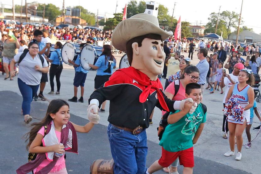 State Fair of Texas mascot "Little Big Tex" escorts two students into the Dallas Mayor's...