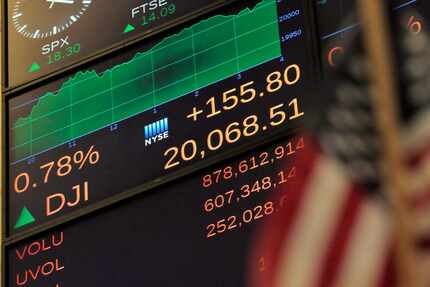 A screen above the floor of the New York Stock Exchange shows the record-high closing number...