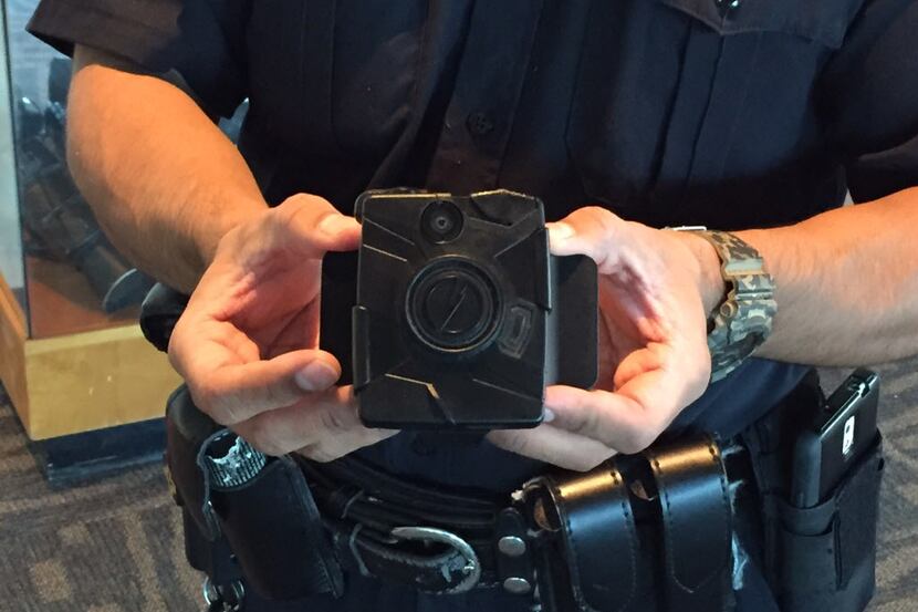 A Dallas police officer displays a Taser Axon Flex body camera at Jack Evans Police...