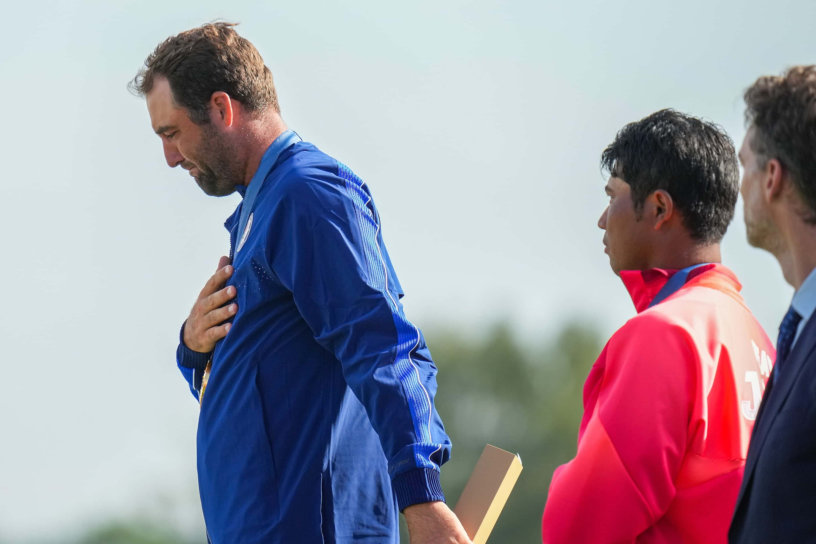 Gold medalist Scottie Scheffler of the United States tears up while the Star Spangled Banner...