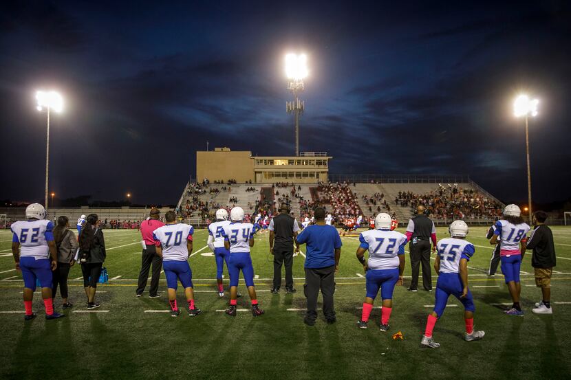 Conrad watch from the sidelines during a high school football game between Conrad and...