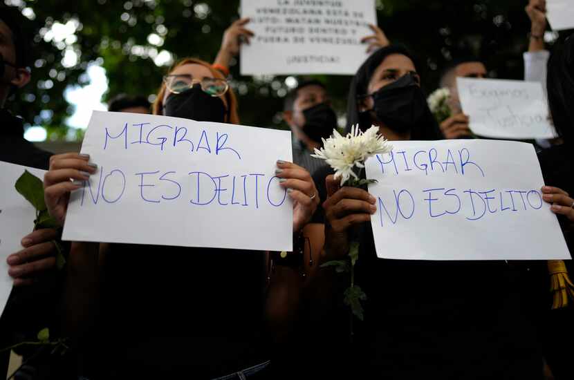 ARCHIVO - Mujeres sostienen carteles durante una protesta frente a la embajada de Trinidad y...