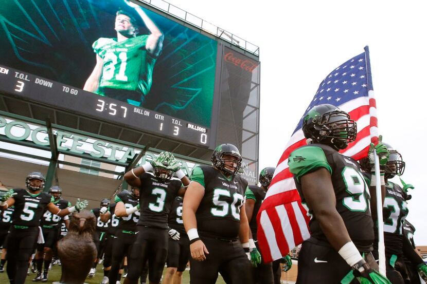 North Texas Mean Green defensive tackle Alexander Lincoln (95) carries the American flag out...