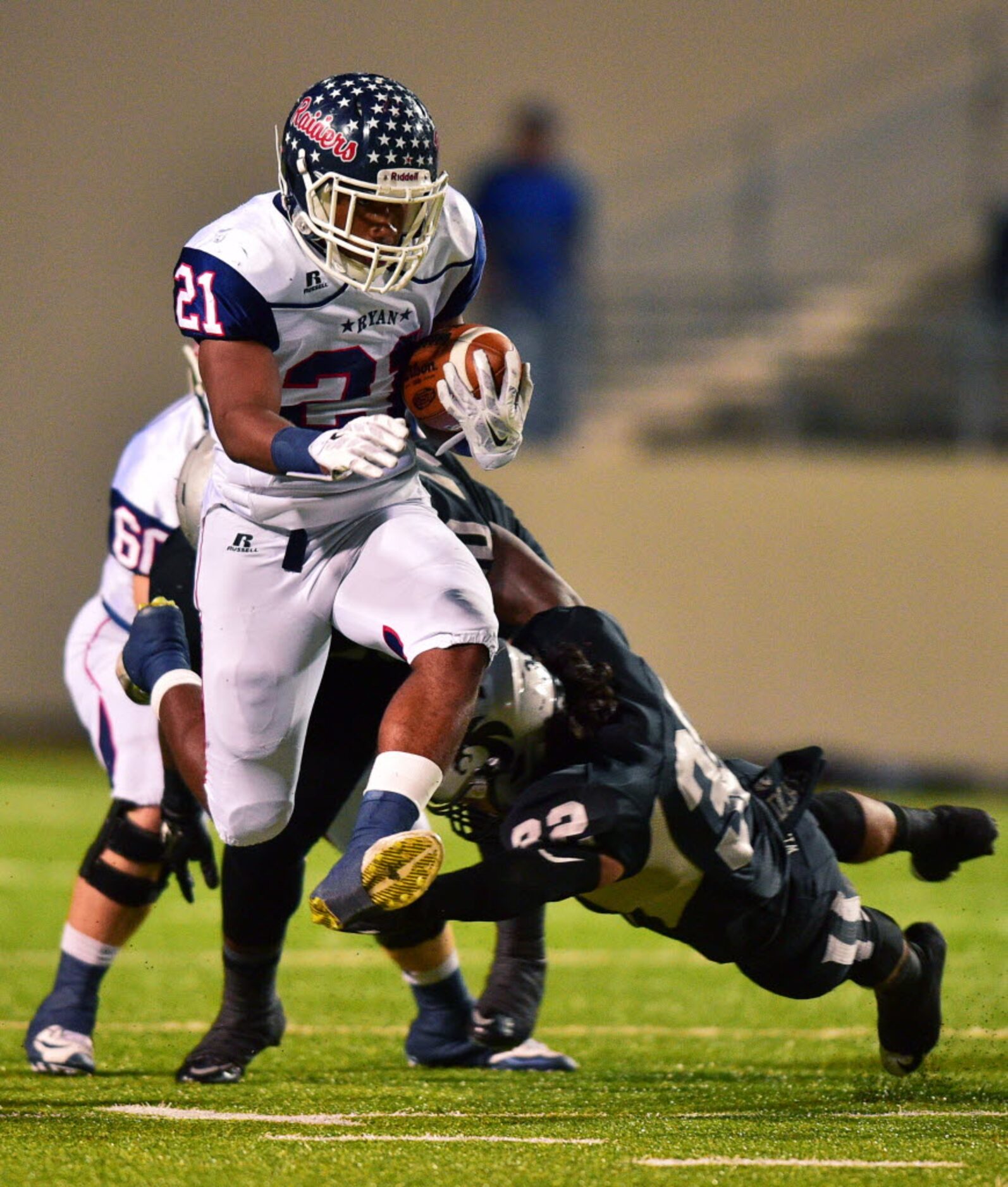 Ryan junior linebacker Tyreke Davis (21) leaps to avoid a tackle by Guyer senior linebacker...