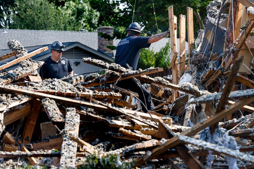 Inspectors from the Plano Fire Marshall office examine the site of a house explosion on the...