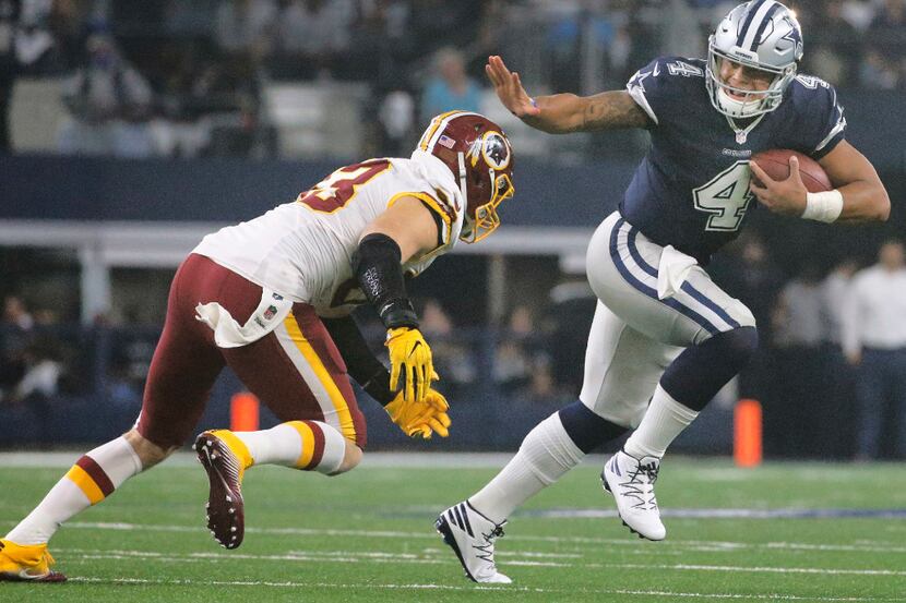 Dallas Cowboys quarterback Dak Prescott (4) applies the stiff-arm to Washington Redskins...