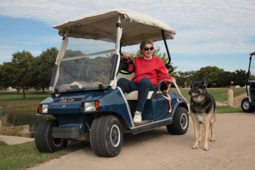Joan McDole, widow of Robert McDole, drives the cart path while walking her dog at Duck...