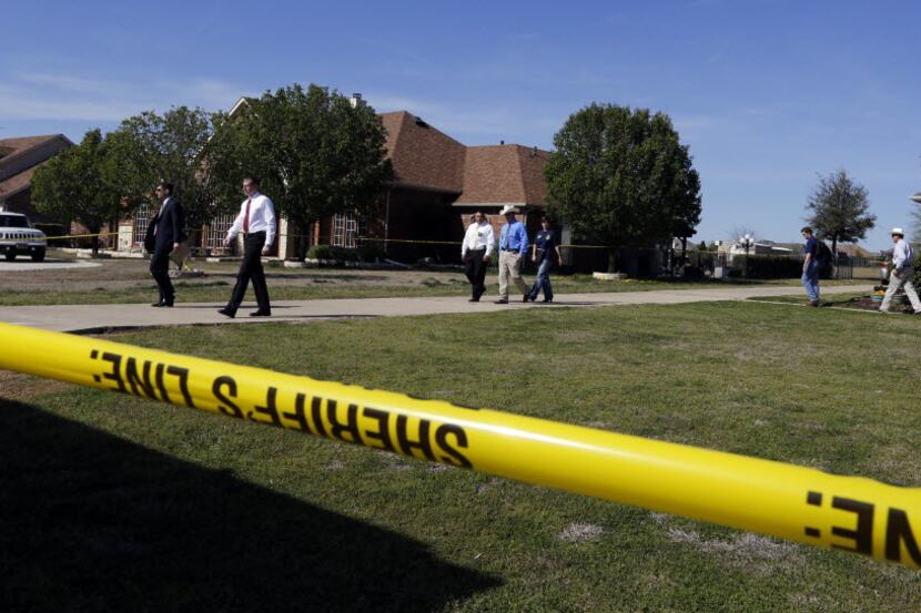 Investigators leaving the home of Mike and Cynthia McLelland near Forney on April 1 (David...