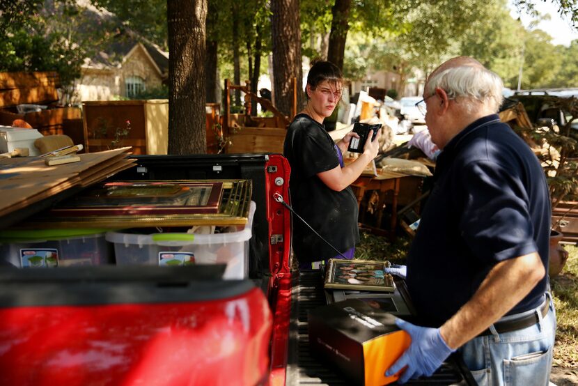 Katie Byrd speaks with her father, Ken Archer, while cleaning out her parents' flooded home...