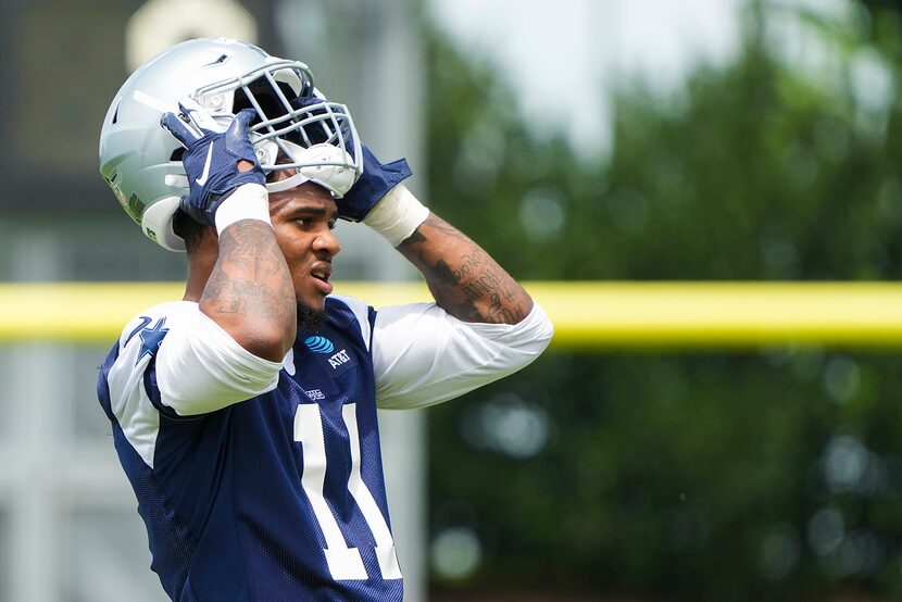 Dallas Cowboys linebacker Micah Parsons puts on his helmet between drills during a minicamp...