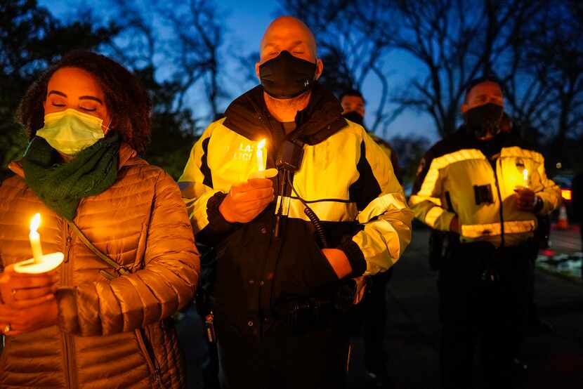 Dallas police officers joined community members at a candlelight vigil for Officer Mitchell...