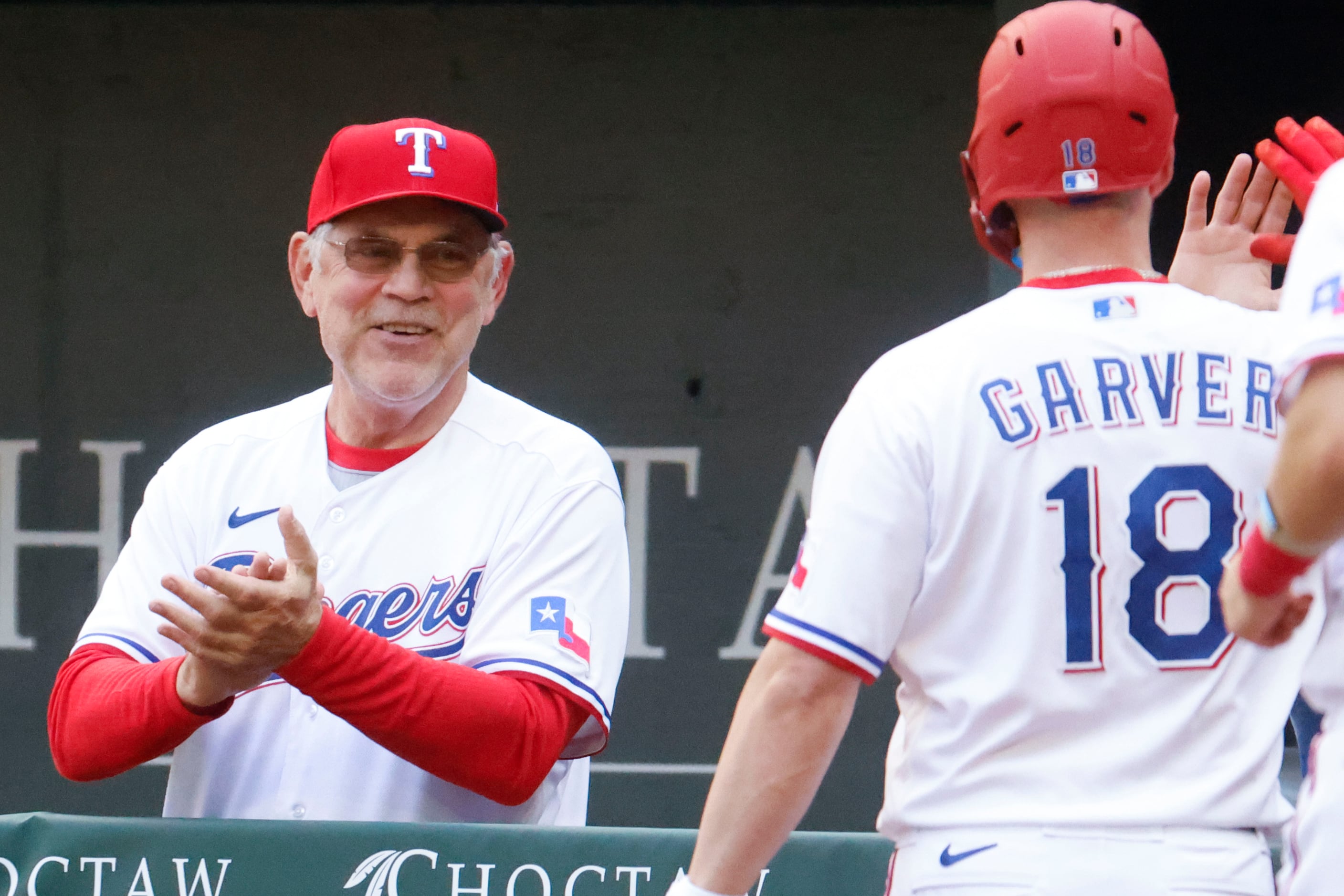 Texas Rangers manager Bruce Bochy (left) cheers towards  catcher Mitch Garver after a home...