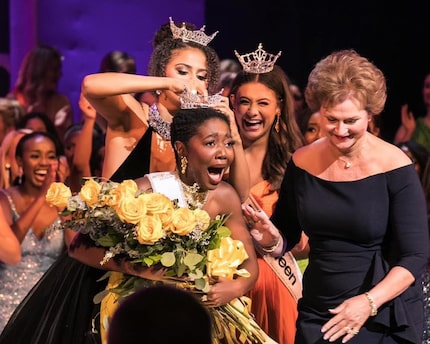 A young woman holding a bouquet of yellow roses is crowned the winner at the Miss Texas...