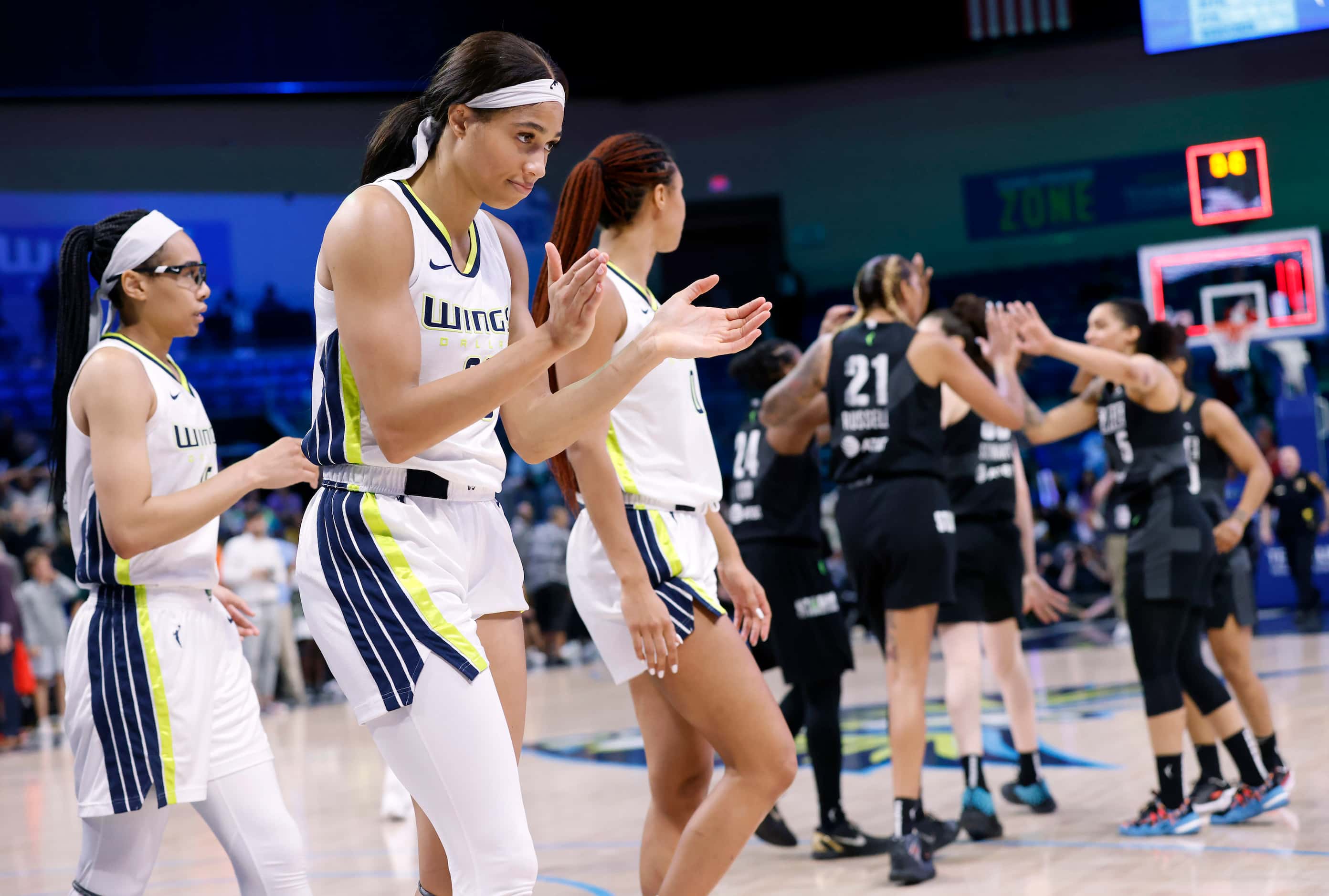 Dallas Wings forward Isabelle Harrison (center) and her teammates react after losing on a...