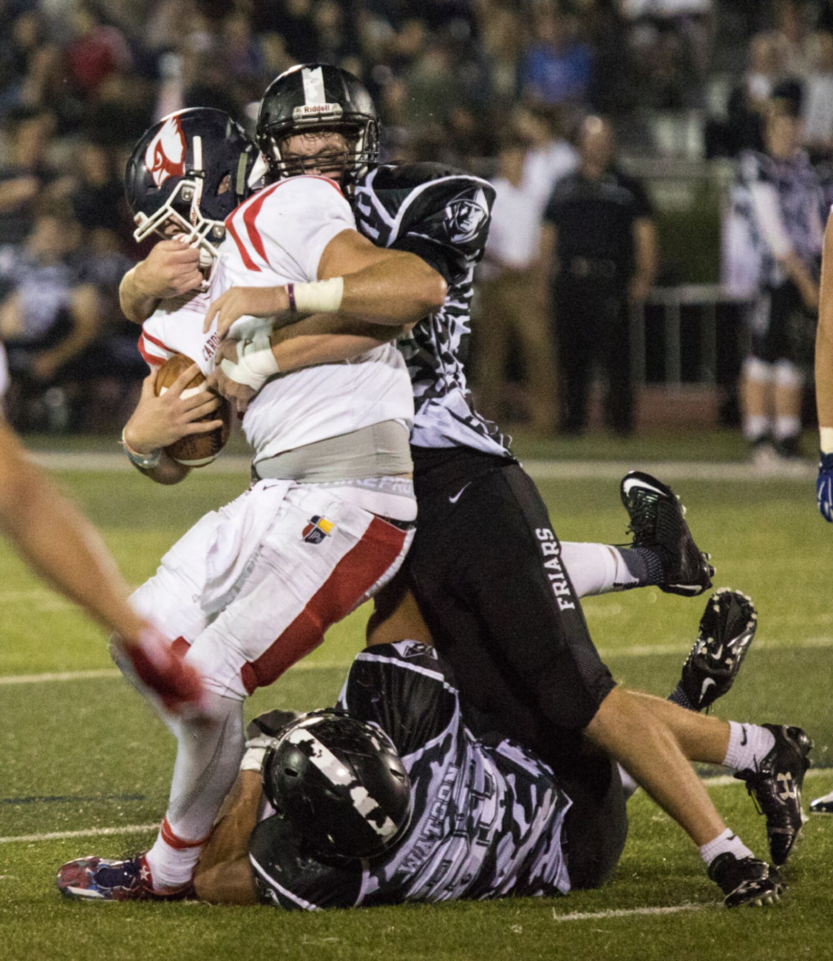 Bishop Lynch defensive lineman Warren Wall (50) brings down John Paul quarterback Austin...