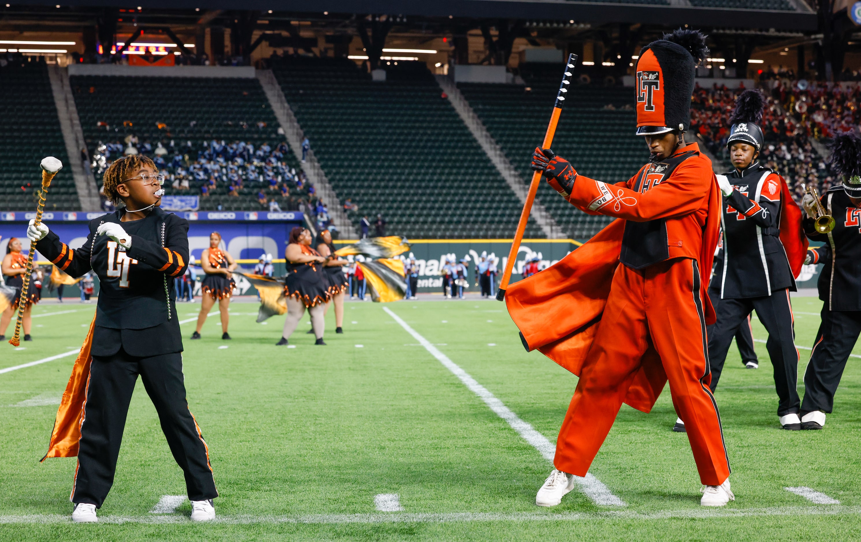 A young Lancaster ISD student looks to a drum major of the Lancaster High School marching...