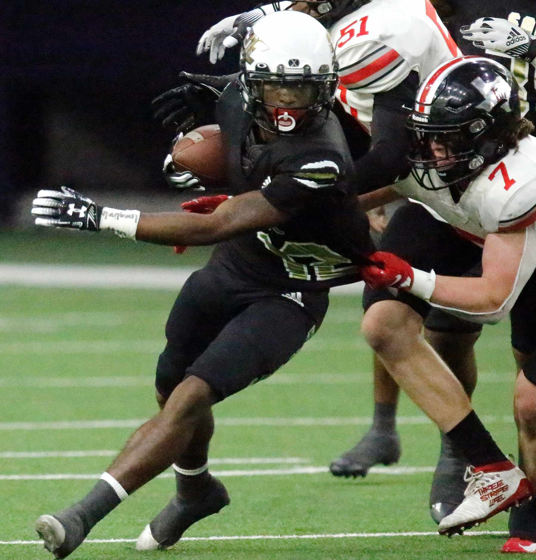 South Oak Cliff High School running back Ke'Undrae Hollywood (12) tries to escape the grasp...