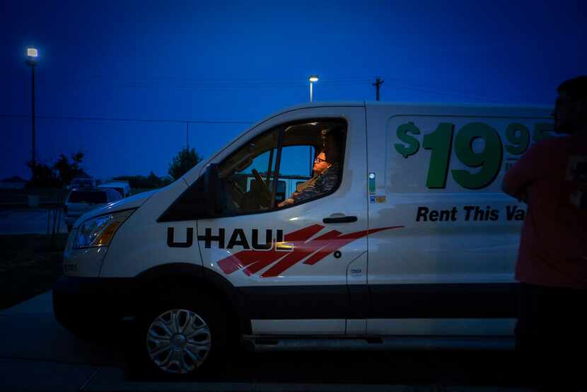 Jeff Slaughter sits in the front seat of a U-Haul van with his wife, Samantha, as his son...