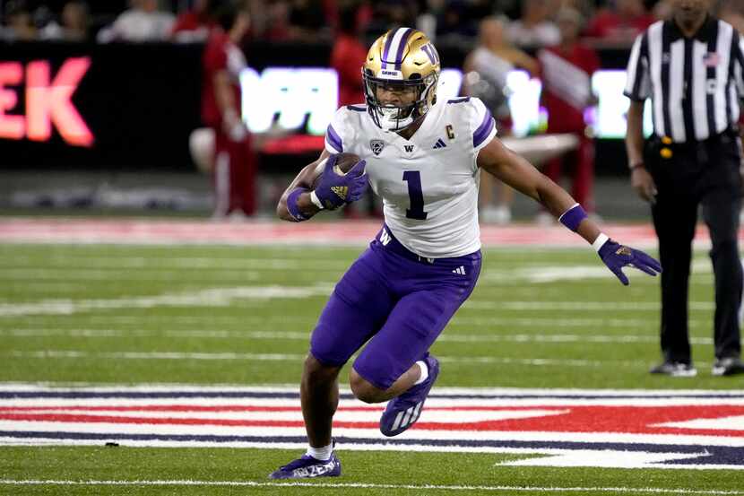 Washington wide receiver Rome Odunze (1) runs the ball in the first half of an NCAA college...